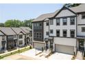 Exterior view of new townhouses with garage, white and black trim, and landscaped grounds at 1312 Stanley Park Dr, Decatur, GA 30033