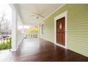 Spacious covered porch featuring a ceiling fan, dark wood floor and a stained wood front door at 338 Clifford Ne Ave, Atlanta, GA 30317