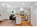 Bright kitchen featuring white cabinets, stainless steel appliances, a breakfast bar, and hardwood floors at 1824 Evans Sw Dr, Atlanta, GA 30310