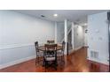 Dining room with wooden floors, table with seating for four, leading to carpeted stairs at 3225 Long Iron Dr, Lawrenceville, GA 30044
