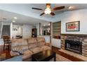 Open-concept living room with ceiling fan, stone fireplace, and views of the kitchen at 3225 Long Iron Dr, Lawrenceville, GA 30044