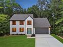 Charming two-story home with orange shutters, a gray roof, an attached two-car garage, and a beautifully landscaped yard at 1920 Rocky Mill Ln, Lawrenceville, GA 30044