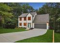 Beautiful two-story home with lush green lawn, gray roof, an attached two-car garage, and a long driveway at 1920 Rocky Mill Ln, Lawrenceville, GA 30044