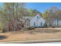 Charming single Gathering home with a stone-accented facade, mature trees, and a well-manicured lawn at 3619 Elinburg Ne Ct, Buford, GA 30519