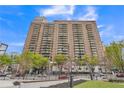 Brick condo building with balconies, landscaping, and parking lot at 620 Peachtree Ne St # 1413, Atlanta, GA 30308