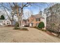 Brick two story home on a large lot with mature landscaping and a sprawling front yard at 2205 Parliament Dr, Lawrenceville, GA 30043
