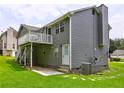 Exterior of the home showcasing a private deck with stairs leading to a patio and lush green backyard at 4090 Mark Todd Ct, Hoschton, GA 30548