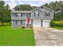 Inviting two-story home with a bright red front door, attached two-car garage, and lush green lawn at 4090 Mark Todd Ct, Hoschton, GA 30548