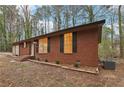 Quaint red brick house featuring large windows and a well-maintained yard with mature trees at 6852 Old Beulah Rd, Lithia Springs, GA 30122