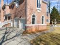 Brick house with three-car garage, and a brick and concrete driveway at 10 Club Ct, Alpharetta, GA 30005