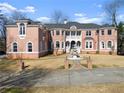 Elegant brick home boasts white trim, arched windows, a fountain, and lush landscaping at 10 Club Ct, Alpharetta, GA 30005