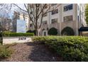 Entrance to high-rise building with beautifully landscaped greenery and modern sculpture at 2479 Peachtree Ne Rd # 912, Atlanta, GA 30305