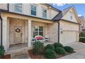 Inviting front porch with brick accents, seating area, and a charming front door with a wreath at 4270 Pleasant Woods Dr, Cumming, GA 30028