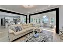 Bright living room with a neutral sectional sofa, an open layout, and views to the kitchen and sunroom at 1887 Lake Ridge Ter, Lawrenceville, GA 30043
