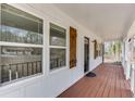 Covered front porch boasting a stained wood floor, white railings, and wood shutters at 2737 King Arthur Ct, Buford, GA 30519