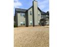 Backyard view featuring a two-story home with siding, a chimney, and a covered patio area at 8413 Members Dr, Jonesboro, GA 30236