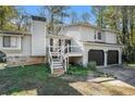 Well-maintained home exterior with a two-car garage, chimney, and inviting staircase entry at 3485 Sheree Trl, Stone Mountain, GA 30087