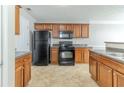 Functional kitchen with wood cabinetry, black appliances, and laminate countertops at 3127 Leyland Ct, Decatur, GA 30034