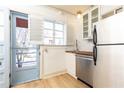 Efficient kitchen with stainless steel appliances, butcher block countertop, white cabinets and door to the outside at 589 Auburn Ne Ave # F, Atlanta, GA 30312