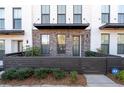 Inviting townhome featuring a brick facade, dark trim, covered entry, and tidy front yard with wood fence at 852 Constellation Dr, Decatur, GA 30033