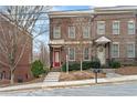 Attractive brick townhomes featuring well-manicured landscaping, complemented by inviting entrances and a sidewalk at 207 Cole Ne St, Marietta, GA 30060