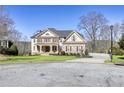 Beautiful home showcasing manicured landscaping, a mix of brick and siding, and a circular driveway at 3433 Pinemont Dr, Douglasville, GA 30135