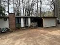 Single story home with a brick chimney and an open porch area; the yard is dirt at 123 Spring St, Stockbridge, GA 30281