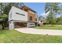 Modern home showcasing clean lines, large driveway, and contemporary design with a well-maintained front lawn at 1653 Wayland Ne Cir, Brookhaven, GA 30319