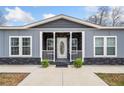 Welcoming front porch with stone accents, white railings, and decorative plants at 3696 Lower Burris Rd, Canton, GA 30114