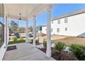 Spacious covered porch with white columns, offering a charming outdoor space with neighborhood views at 83 Arnold Poplar Ln, Auburn, GA 30011