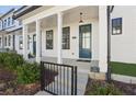 Welcoming front porch with classic white columns, a vibrant teal door, and a stylish hanging light at 83 Arnold Poplar Ln, Auburn, GA 30011