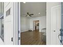 Inviting living room with wood floors, ceiling fan, and view into the kitchen at 83 Arnold Poplar Ln, Auburn, GA 30011