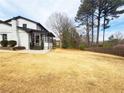 Expansive backyard featuring a screened-in porch and mature trees, offering privacy and space for outdoor activities at 2167 Cedar Dr, Lawrenceville, GA 30043