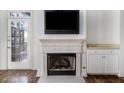 Close up of fireplace with white mantel, mounted tv, and french doors in living room at 850 Piedmont Ne Ave # 1302, Atlanta, GA 30308
