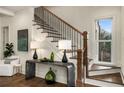 Elegant staircase with dark wood rails, white risers, and a modern console table adorned with decorative accents at 993 Northrope Ne Dr, Atlanta, GA 30324