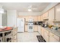 Well-lit kitchen with tiled floor, light wood cabinets, white appliances and a breakfast nook at 4809 Shae Ct, Powder Springs, GA 30127