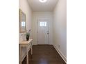 View of the entryway with dark floors, white walls, and decorative furniture at 5316 Radford Loop, Fairburn, GA 30213