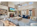 Sophisticated living room featuring a stone fireplace, built-in shelving, vaulted ceiling, and plush blue sofas at 644 Herring Rd, Grayson, GA 30017