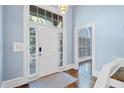 Bright foyer with hardwood floors, white door with glass sidelights, and soft blue walls at 31 Greenland Trce, Atlanta, GA 30342