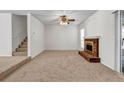 Bright living room with cozy fireplace and plush carpet next to a staircase at 114 Belmonte Sw Dr, Atlanta, GA 30311