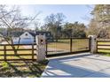 Gated driveway entrance to a beautiful home with a manicured lawn at 770 Winding Creek Trl, Dacula, GA 30019