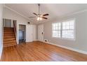 Bright living room with hardwood floors, ceiling fan, and staircase access at 774 Marthas Dr, Lawrenceville, GA 30045