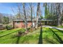 Charming brick home with a covered carport and a lush green lawn at 2664 Homeland Dr, Atlanta, GA 30360
