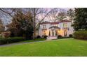 Charming two-story white home with a red tile roof, beautiful landscaping, and manicured lawn at 401 Peachtree Battle Nw Ave, Atlanta, GA 30305