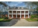 Beautiful brick home with a columned front porch, second story balcony, and manicured landscaping at 0 Winterthur, Sandy Springs, GA 30328