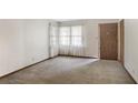 Bright living room features a large window with sheer curtains and a neutral carpet at 4676 Ridgewood Dr, Forest Park, GA 30297