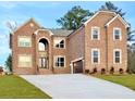 Two-story brick home featuring a well-manicured front yard and a concrete driveway at 206 Lotus Ln, Covington, GA 30016