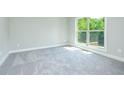 Carpeted bedroom with white trim, a double hung window, and an electrical outlet at 218 Lotus Ln, Covington, GA 30016