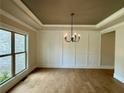 Elegant dining room features tray ceilings, wainscoting, hardwood floors, and a modern chandelier at 218 Lotus Ln, Covington, GA 30016