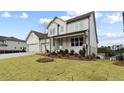 Charming two-story home featuring a well-manicured lawn at 227 Wild Ginger Bnd, Woodstock, GA 30188